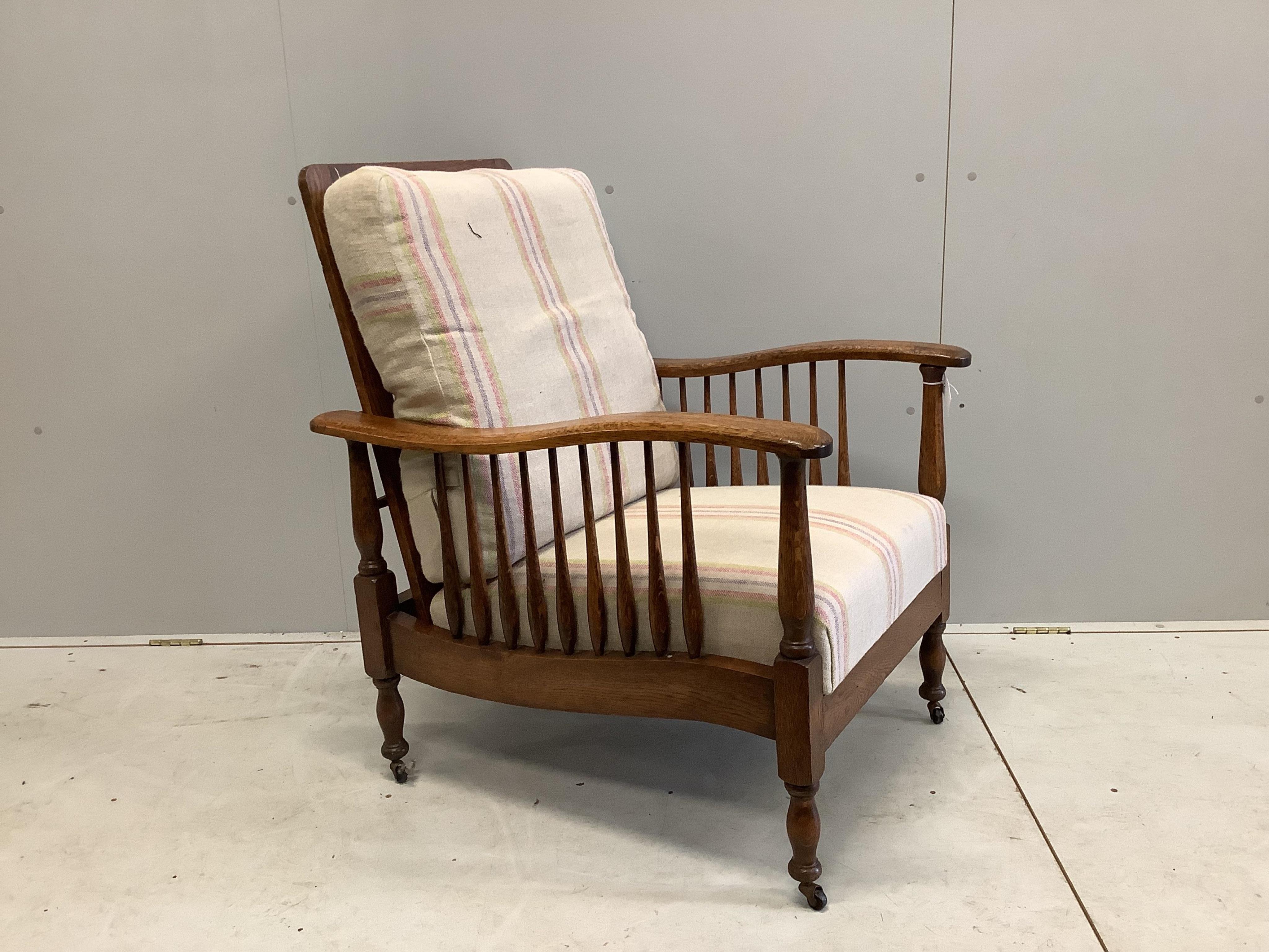 An Arts & Crafts oak armchair with adjustable back, width 66cm, depth 80cm, height 95cm. Condition - good